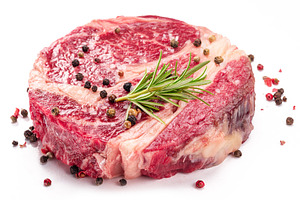 Raw beef steak with herbs and spices ready for cooking on white, a Food & Drink Photo by Volff