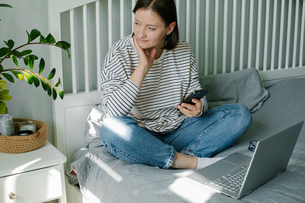 Young woman working from home office. Freelancer using laptop, phone and the In, a Person Photo by Anikona