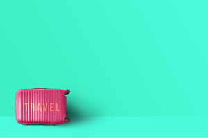 Pink suitcase standing next to the t