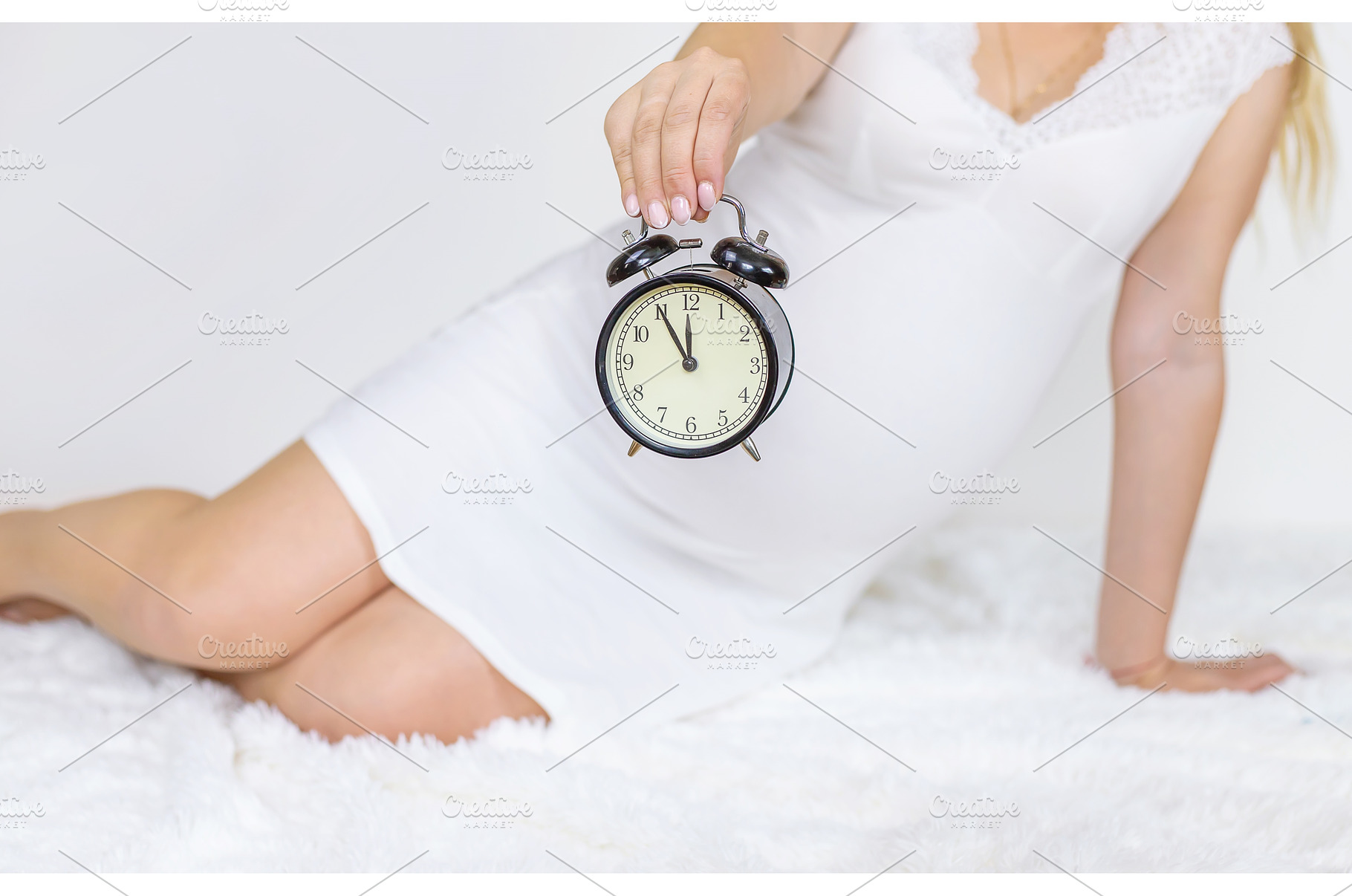 The pregnant woman holds an alarm, a Person Photo by yanadjana
