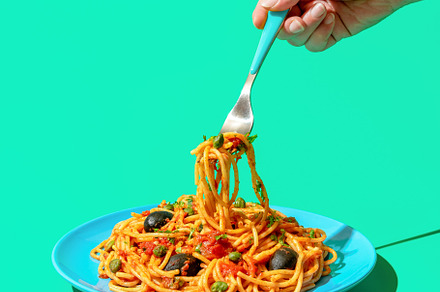 Eating spaghetti puttanesca, a vegan pasta dish, minimalist on a, a Food & Drink Photo by YesPhotographers