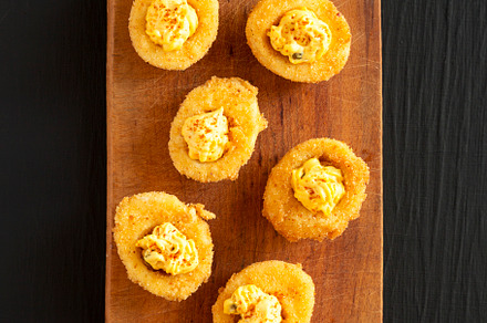 Homemade Deep-fried Deviled Eggs with Paprika on a rustic wooden, a Food & Drink Photo by LiudmylaChuhunova