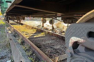 An abandoned railway track with overgrown grass and weeds, showing the undercar, an Industrial Photo by Textures & Backgrounds