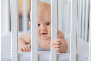 Sad baby looking through the bars of, a Person Photo by Elizaveta Galitskaya