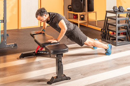 Adult man doing push ups on bench in the gym, a Sports & Recreation Photo by Iván Moreno STOCK PHOTO