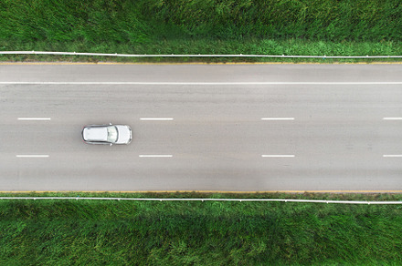 car on the street with green grass