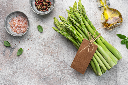 Bunch of raw asparagus stems with different spices, a Food & Drink Photo by Olena Rudo