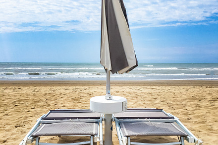 Two sunbeds and an umbrella closed, a Sports & Recreation Photo by KYNA STUDIO