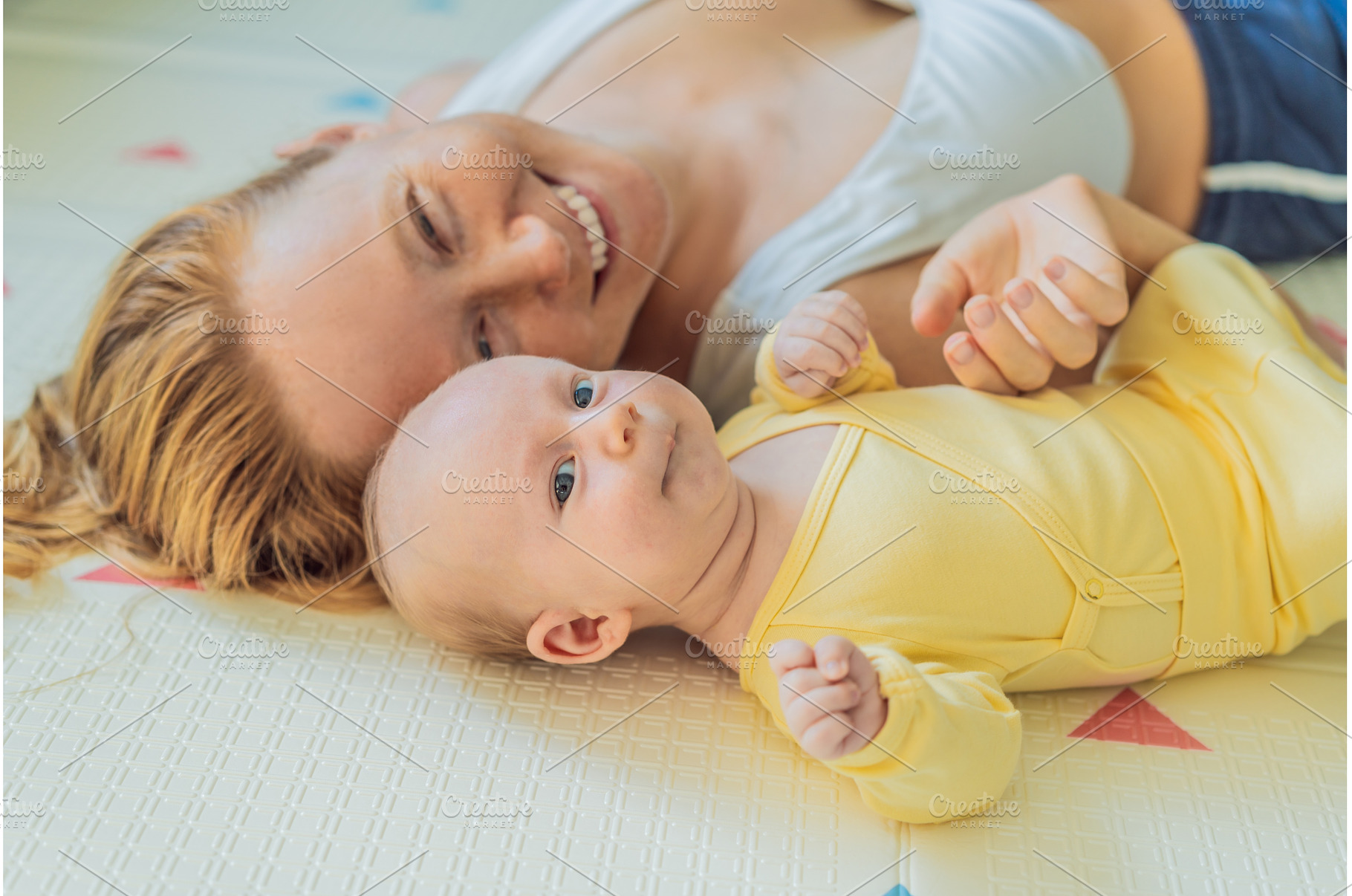 Mother and baby lying on a play mat, a Person Photo by Elizaveta Galitskaya