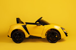 Side view of a yellow toy sports car with black details, isolate, a Transportation Photo by Ales Munt