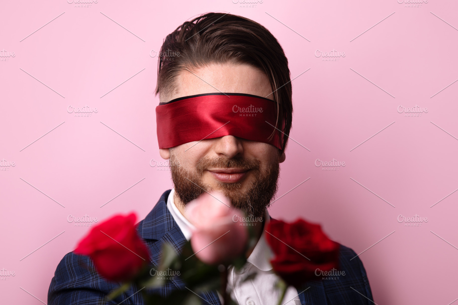Smiling man in suit blindfolded with red ribbon, standing behind, a Person Photo by Ales Munt