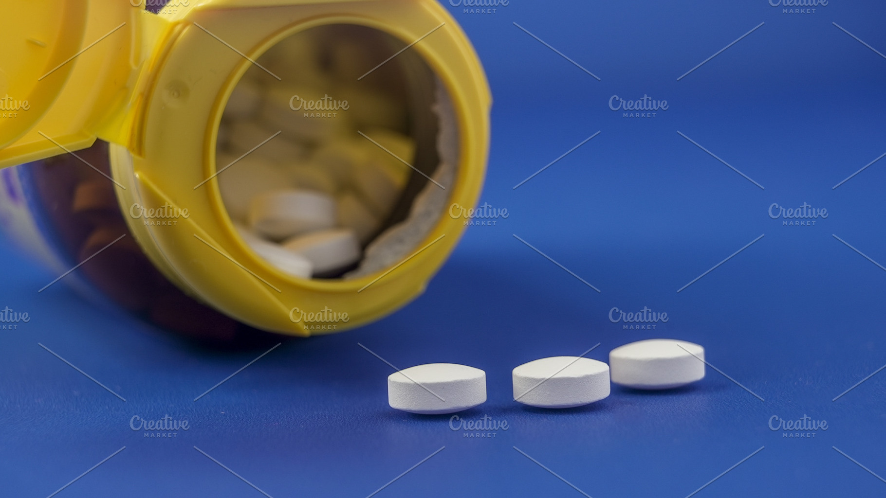 Bottle of white pills spilling onto, a Health & Medical Photo by 1miromiro