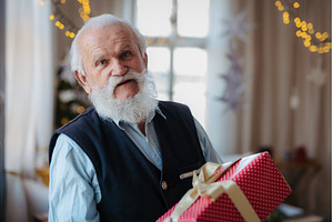 Senior man holding Christmas gift., a Person Photo by HalfPoint
