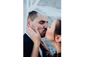 Young wedding couple kissing, a Person Photo by HalfPoint