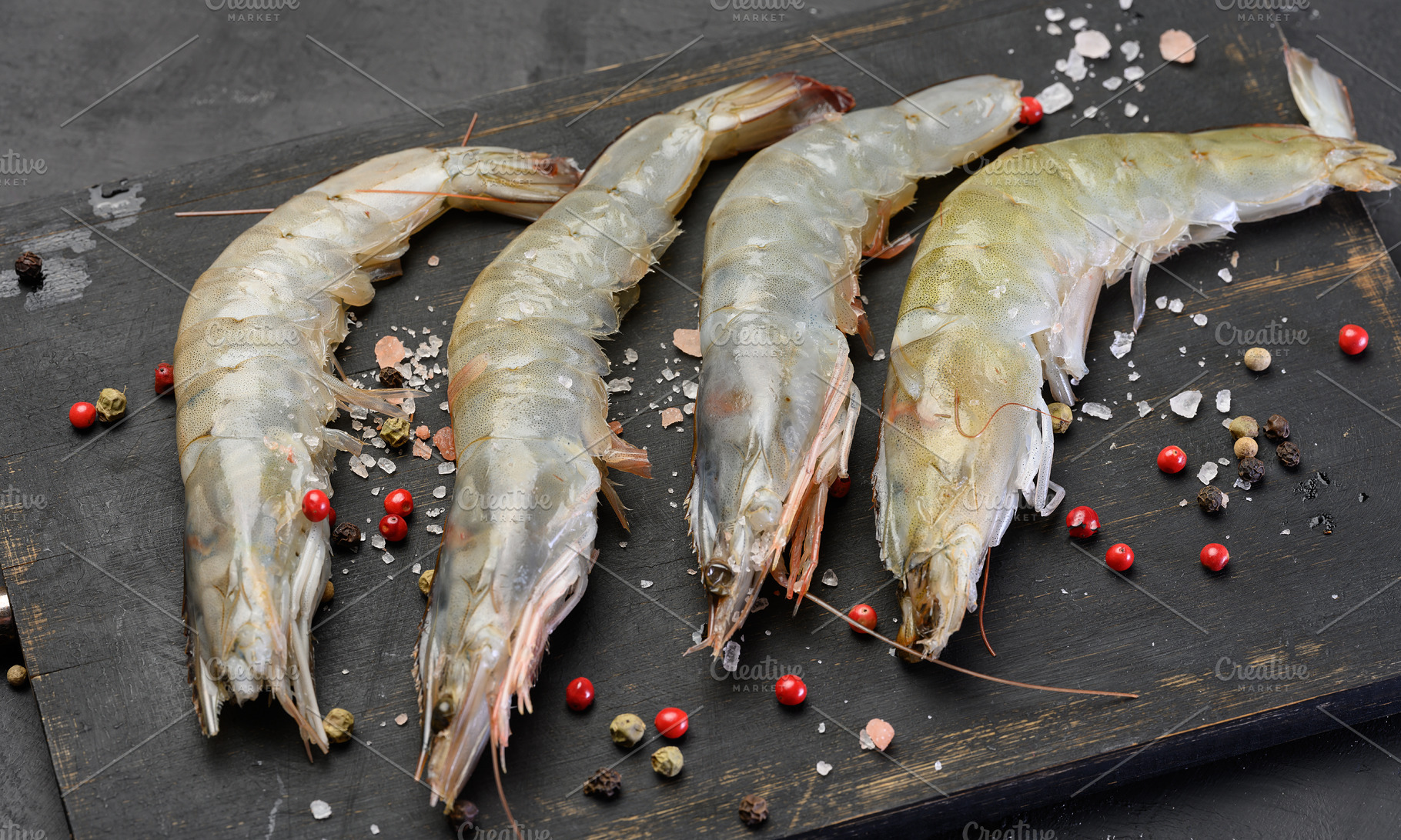Raw tiger prawns, pink pepper, sea salt, black wooden surface, a Food & Drink Photo by ndanko