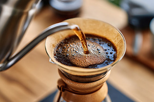 Slow drip coffee maker prepares rich, aromatic brew in a cozy setting, a Food & Drink Photo by AlyaAnd