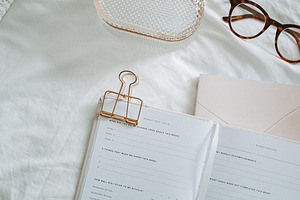 Planner and Glasses on Bed