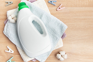 Laundry detergent bottle with towels, cotton and clothespins, an Industrial Photo by Olena Rudo