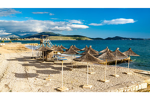 Straw umbrellas on a beach in stock photo containing beach and umbrella, a Nature Photo by Leonid Andronov