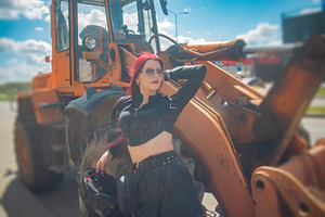 Red haired woman posing near heavy industrial loader with cloudy, a Photo by Pictures for you!!!!!!!!!