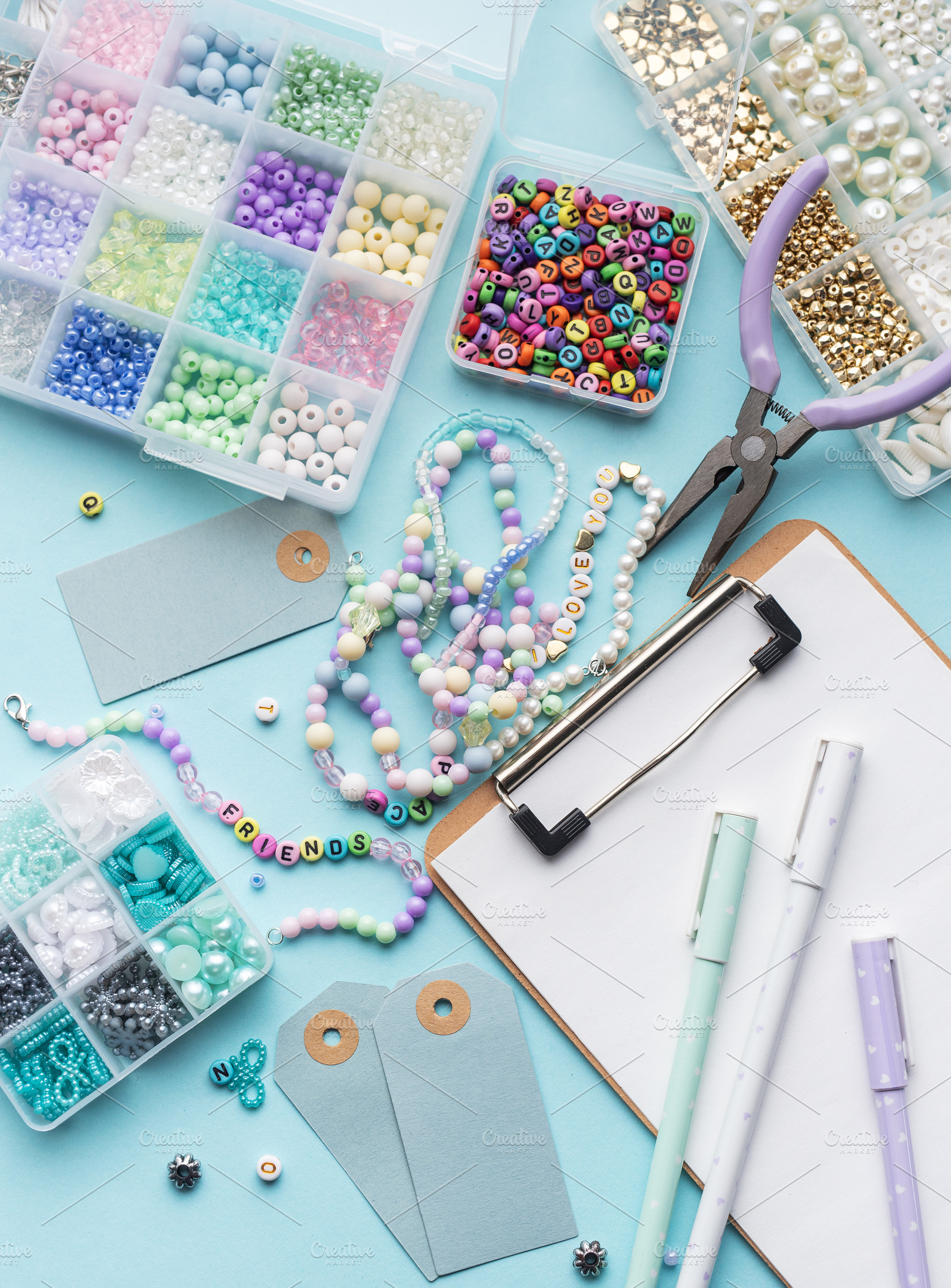 Colorful beads, pliers, clipboard and price tags arranged on blu, an Arts & Entertainment Photo by Olena Rudo