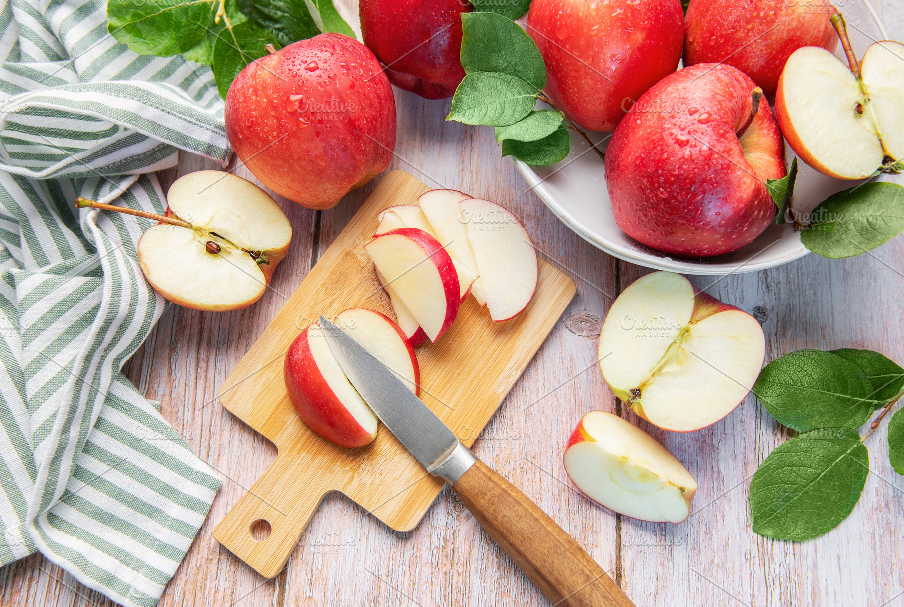 Fresh aed apples slicing on wooden cutting board, a Food & Drink Photo by Olena Rudo