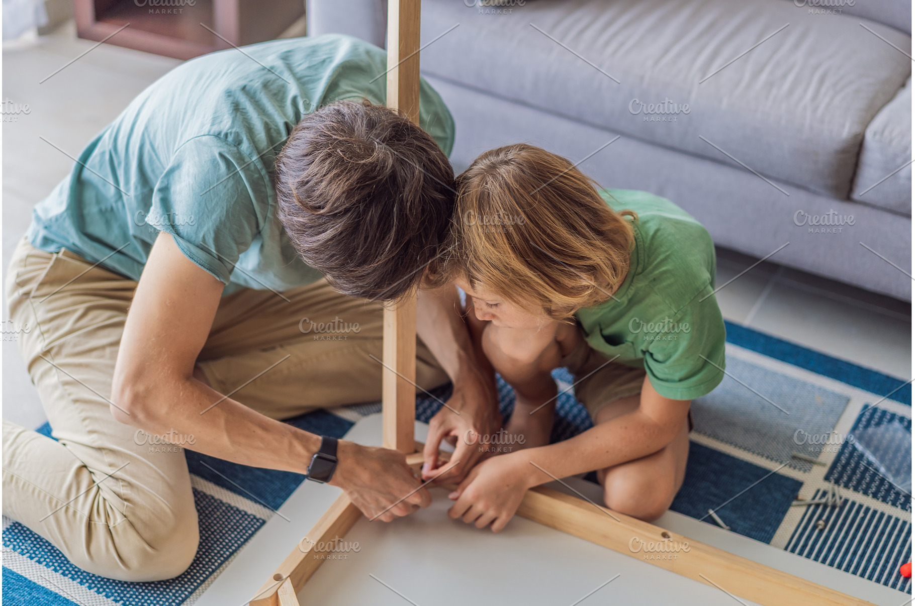 Father and his son assembling a, a Person Photo by Elizaveta Galitskaya