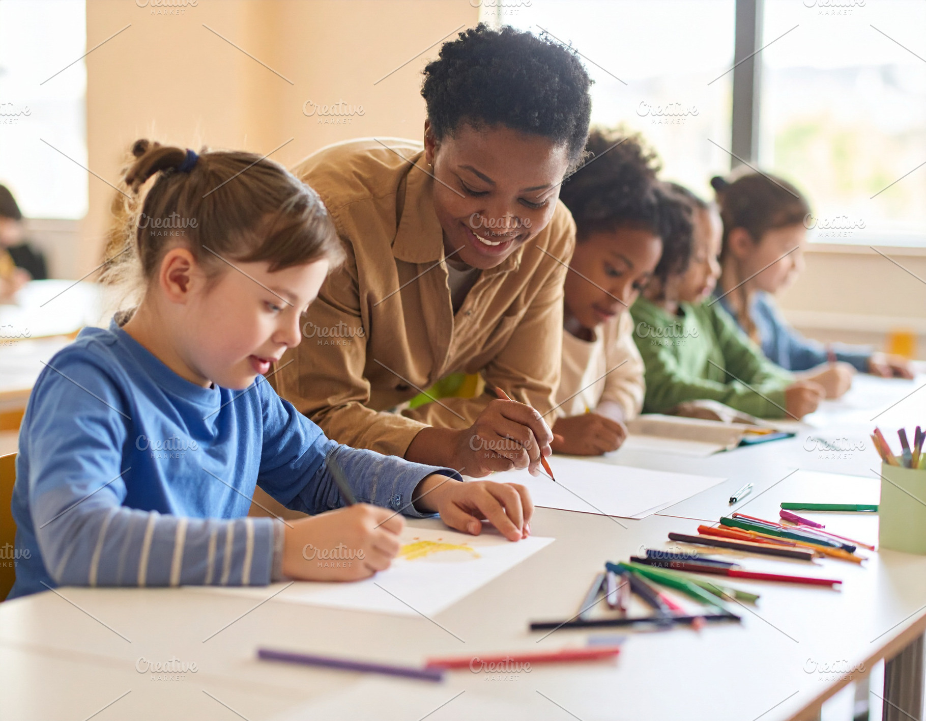 Young teacher with down syndrome girl at classroom, a School & Education Photo by DanFLCreativo