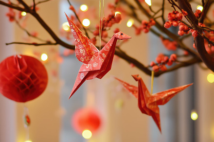 Colorful origami cranes hanging from a decorative tree with red blossoms and la, an Arts & Entertainment Photo by Textures & Backgrounds