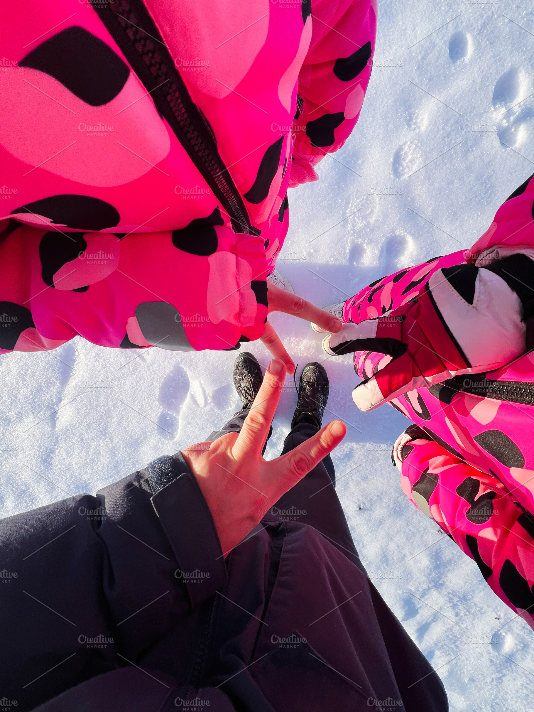 Friends in bright pink camo jackets standing in the snow, top view, winter outd, a Photo by AS photostudio