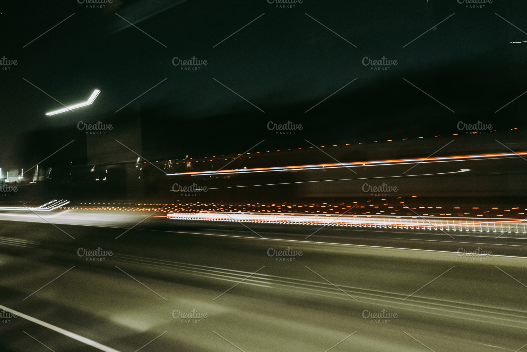 Light trails of a moving vehicle at night on the road, an Abstract Photo by GoodGoods