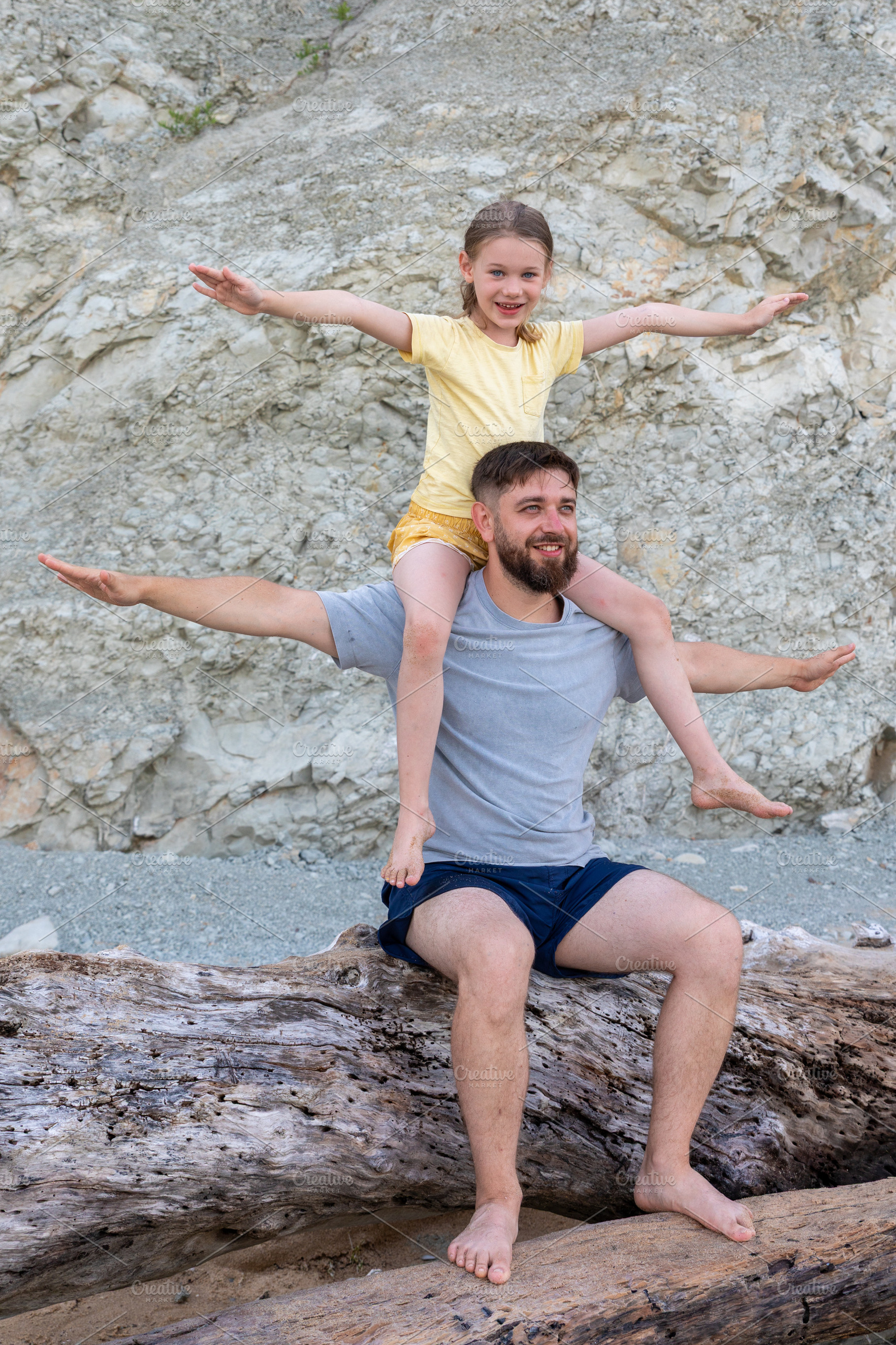 Smiling father with daughter on shoulders, both with outstretched arms, enjoyin, a Person Photo by Ales Munt