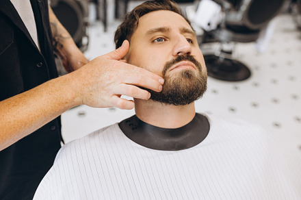 Professional barber, clipper cutting, shaving beard of regular customer at barb, a Person Photo by Volodymyr Melnyk