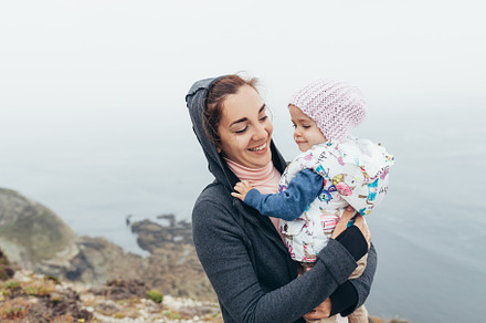 Mother and little daughter standing rock ocean beach autumn season, a Person Photo by andreonegin market