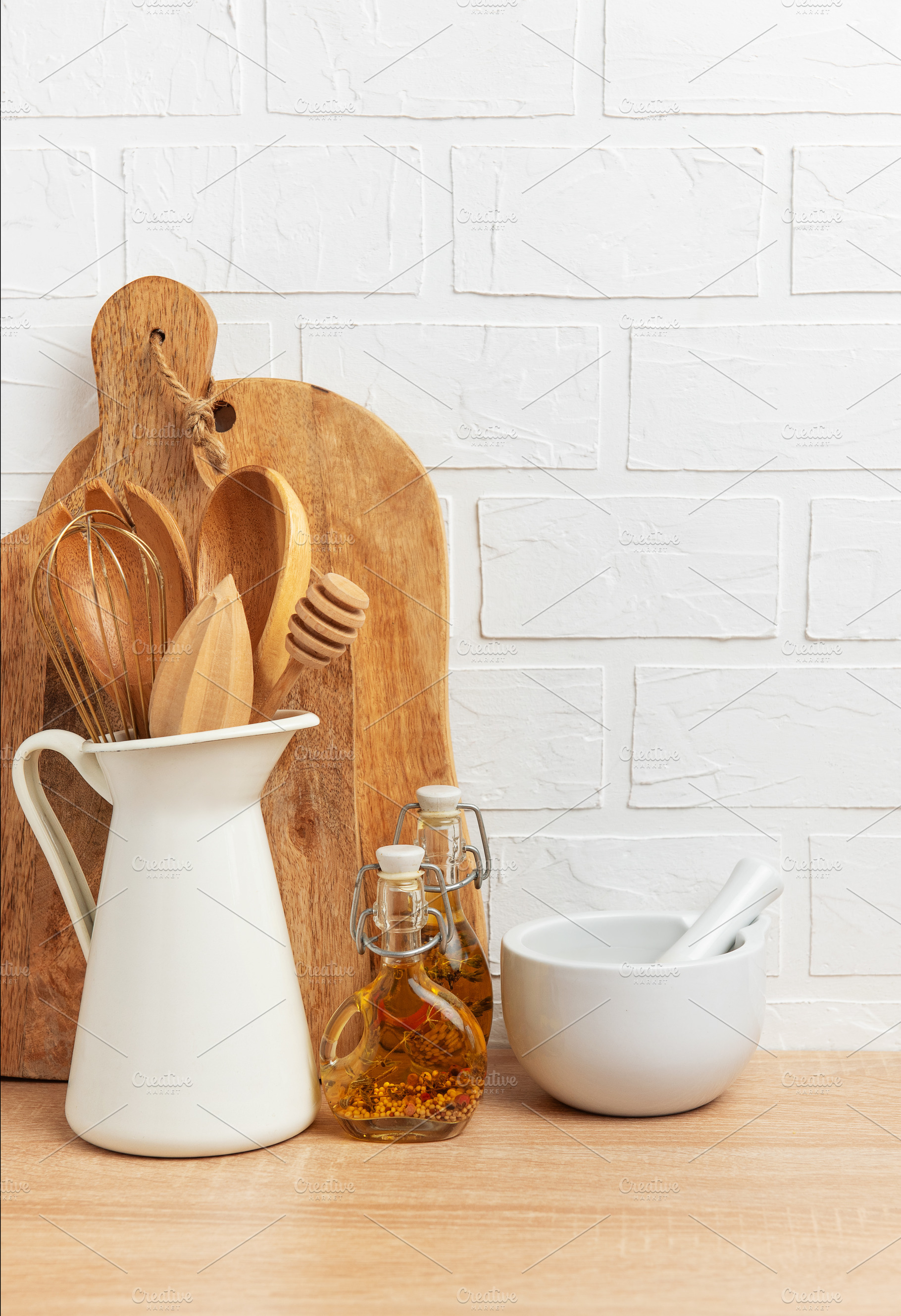 Kitchen utensils resting on wooden countertop with white brick w, a Food & Drink Photo by Olena Rudo