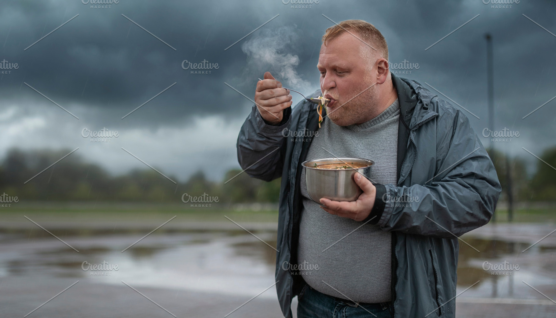 Afult man eating hot food outdoors, a Person Photo by DanFLCreativo