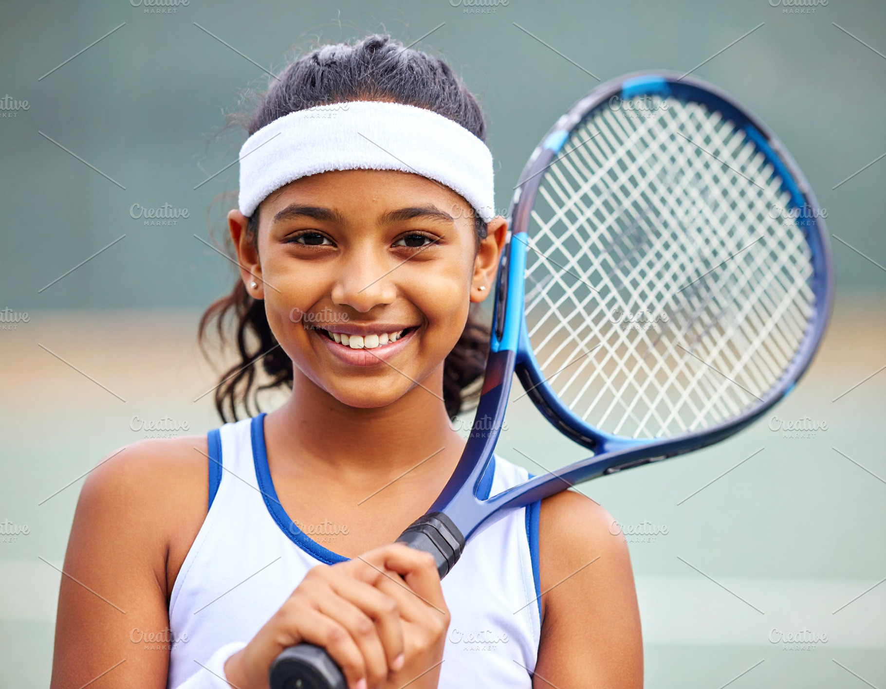 Smiling girl holding tennis racket, a Sports & Recreation Photo by DanFLCreativo