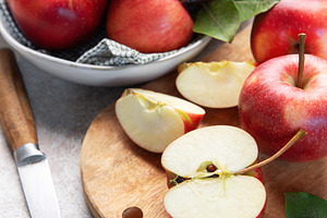 Red apples, whole and sliced, on cutting board, a Food & Drink Photo by Olena Rudo