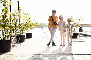 Three children outdoors enjoying a sunny day on a modern patio, a Person Photo by AS photostudio