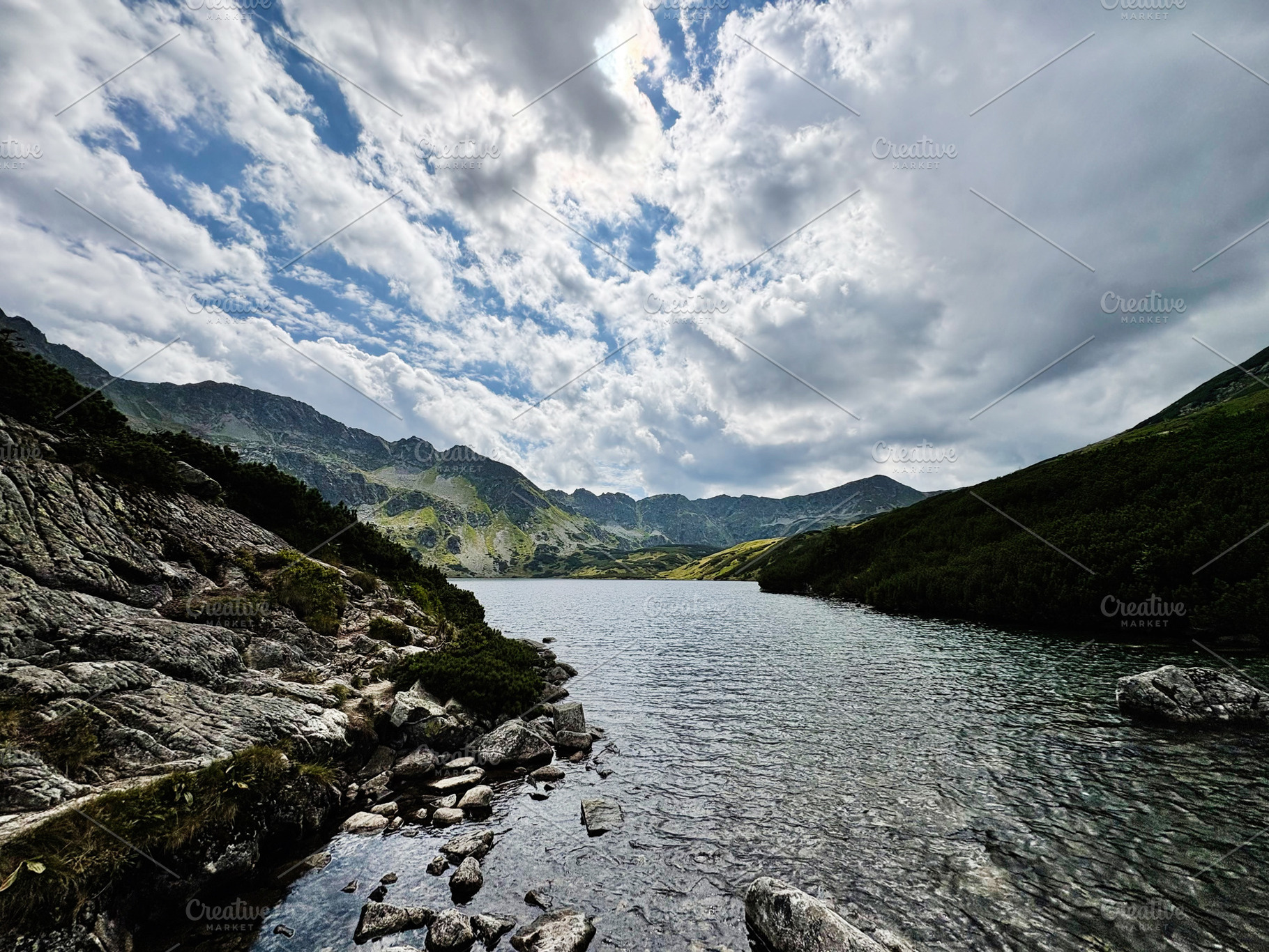 Scenic mountain lake in Zakopane Poland with rocky shore and dramatic clouds, a Nature Photo by AS photostudio