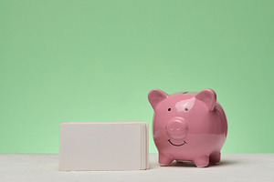 Pink ceramic piggy bank and stack of white business cards on gre, a Business Photo by ndanko