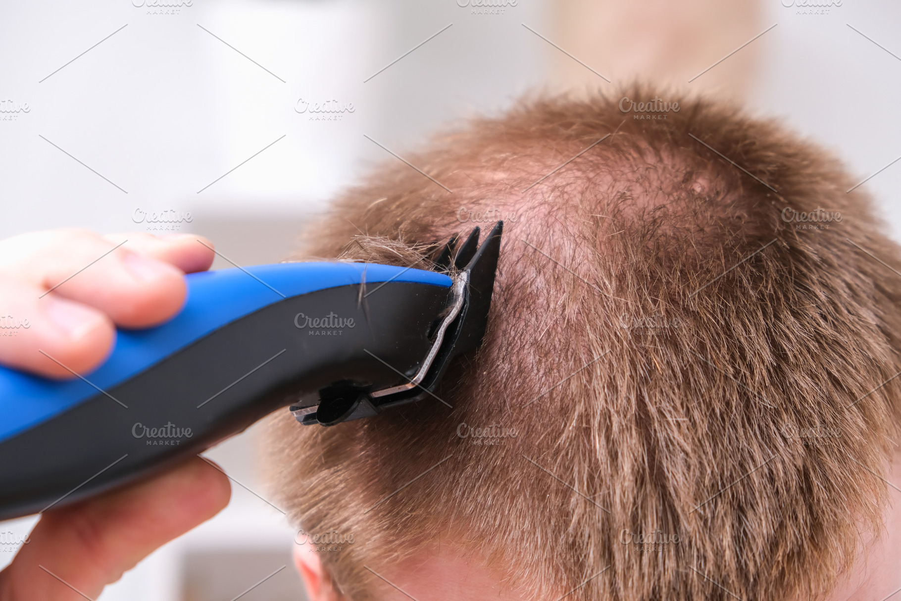 A man cuts his hair with clipper. Cutting a short hairstyle at home. Close-up., a Technology Photo by Detriana