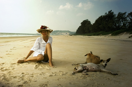 Girl in hat with dogs on the beach