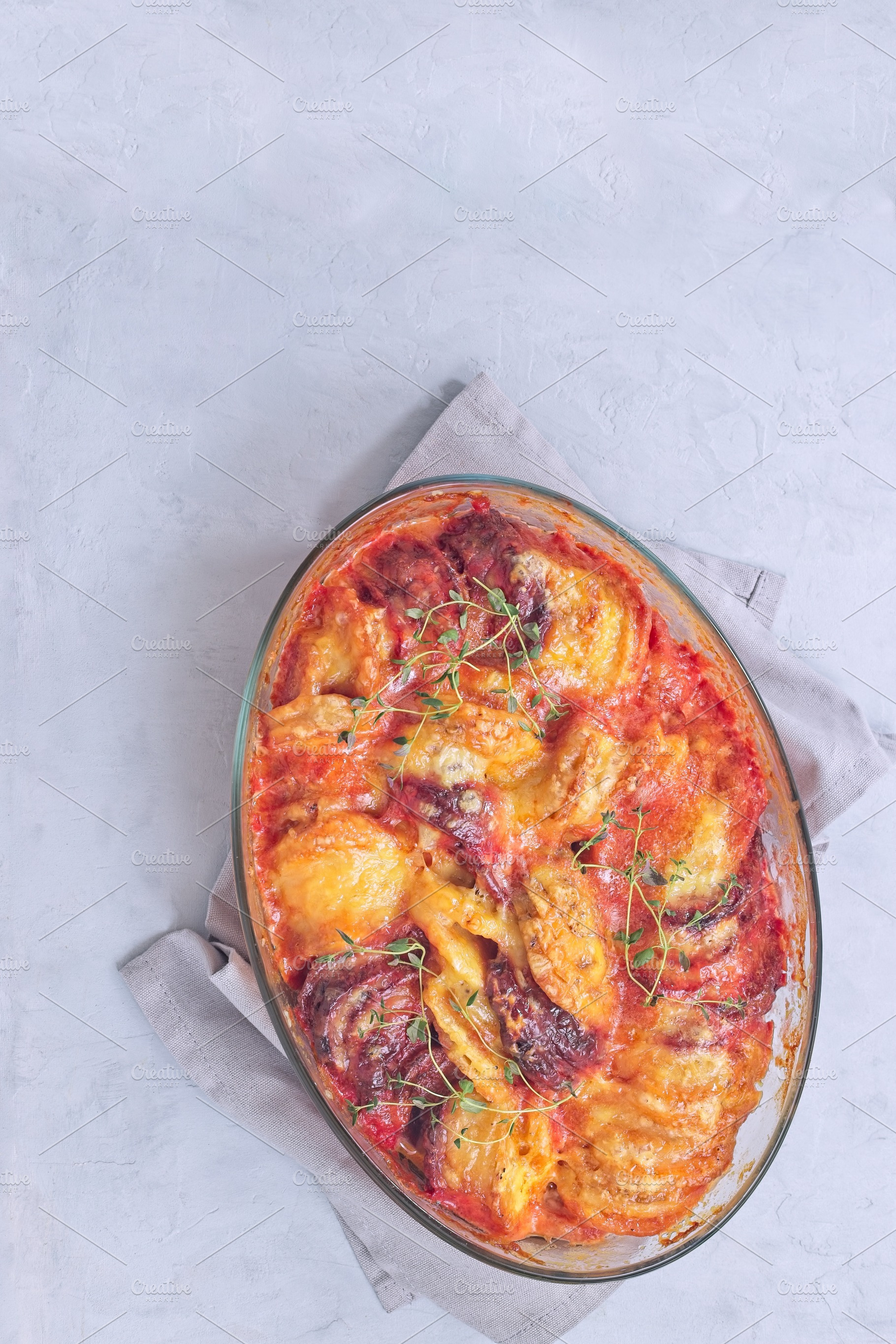Gratin with sweet potato, parsnips, beet root and melted cheese, in glass dish,, a Food & Drink Photo by iuliia_n