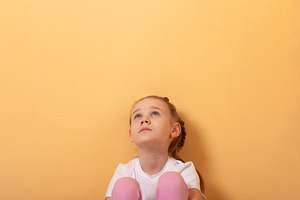 Young girl in white t-shirt and pink pants sitting and looking u, a Person Photo by Ales Munt