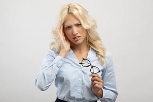 Stressful job. Female office employee feeling overworked, having severe headach, a Photo by Prostock-Studio