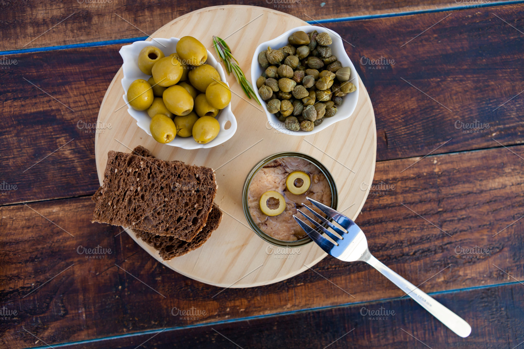 Tuna can next to a bowl of olives and capers, a Food & Drink Photo by José Manuel Gelpi