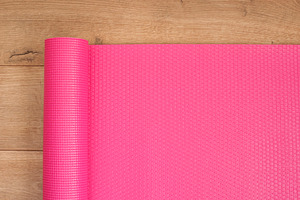 Pink yoga mat on a wooden background featuring yoga, mat, and background