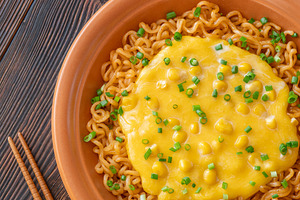 Cheesy corn ramen with scallions and wooden chopsticks on dark r, a Food & Drink Photo by Alexander Prokopenko