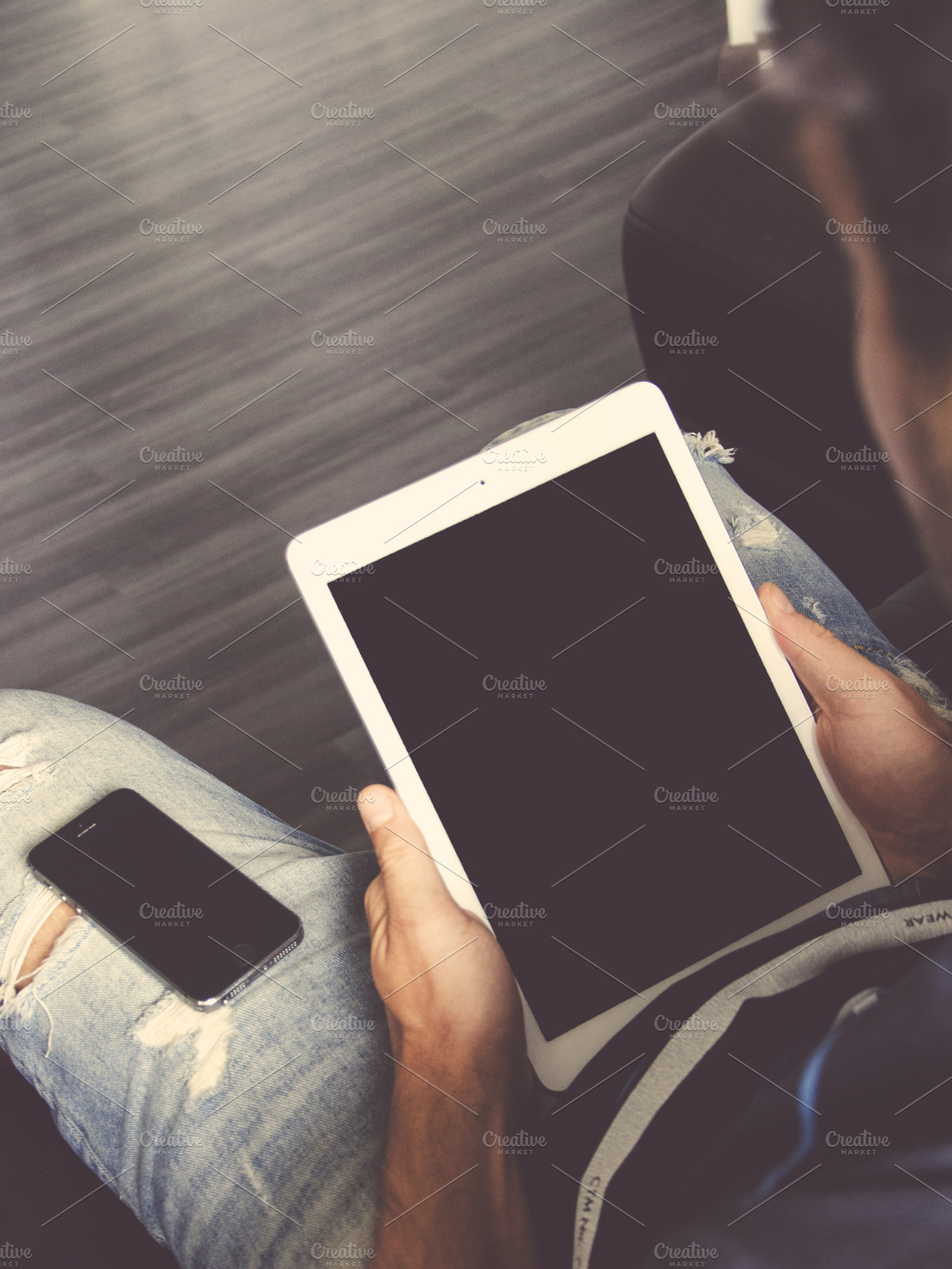 Man holding a white Ipad and Iphone